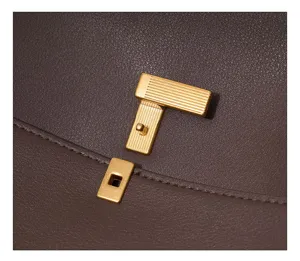 Nahaufnahme eines braunen Damen Lederhandtasche Details mit elegantem goldfarbenen Metallverschluss.