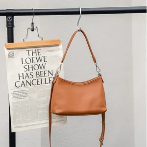 Detail view of the brown leather shoulder bag, premium cowhide, elegant curved design for women.