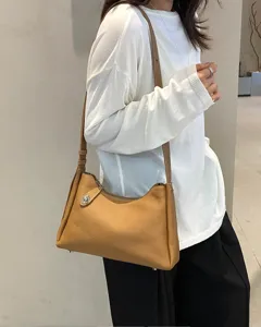 Close-up detail of stylish brown leather shoulder bag worn by model, premium craftsmanship.