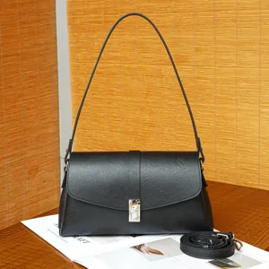 Detailed view of the black leather shoulder bag showcasing fine texture and metal lock.