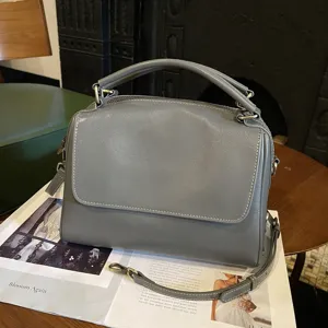 Retro leather boston bag for women, elegant grey shoulder handbag with top handle and strap.