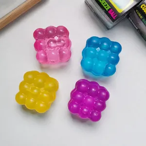 Detail view of colorful translucent square bubble squeeze toy, soft rubber relief toy.