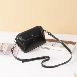 Classic black leather crossbody bag with flap and slim strap for women detail view.