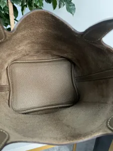 Vista dettagliata dell'interno della borsa secchiello in pelle con consistenza e lavorazione.