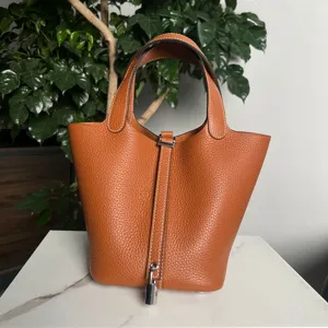 Borsa a secchiello in pelle arancione con lucchetto argentato, borsa a mano da donna.
