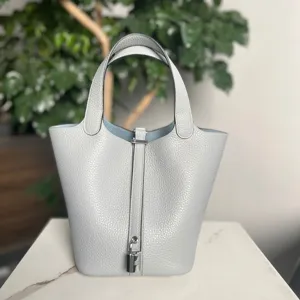 Borsa a secchiello in vera pelle di lusso con manico superiore e serratura in metallo.