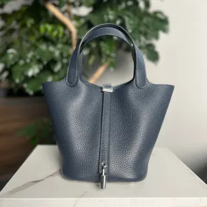 Borsa a secchiello in vera pelle dettaglio, design minimalista classico con chiusura in metallo.