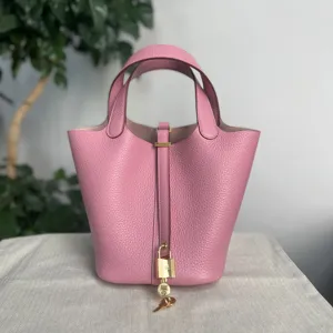 Vista dettagliata della borsa a secchiello in pelle rosa con texture fine e dettagli metallici.