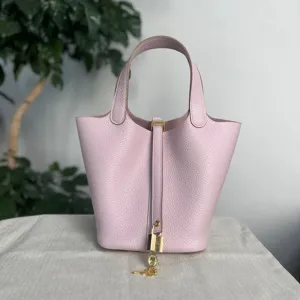 Borsa a secchiello in pelle rosa chiaro con lucchetto e manici superiori per donne stile casual.