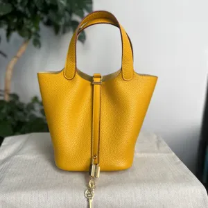 Borsa secchiello in pelle gialla con manici e ciondolo a lucchetto per la moda quotidiana donna.