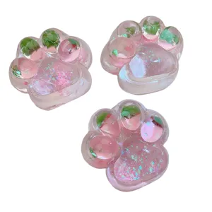 Transparent pink cat paw squishy toy with glitter and cute strawberry inside for stress relief.