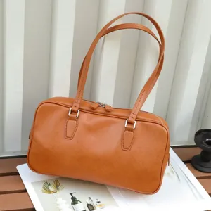 Detailed shot of vintage brown leather shoulder bag with metal zipper and twin straps.
