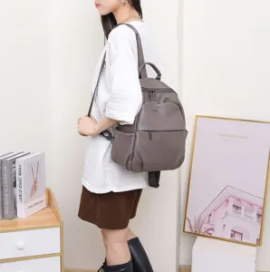 Stylish grey genuine leather backpack for women, casual travel daypack with multiple pockets.