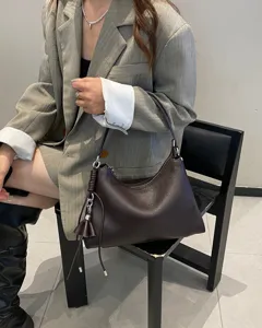 Vista dettagliata della borsa a spalla hobo in vera pelle marrone scuro con nappina e zip.