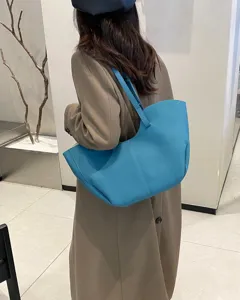Dettaglio della borsa tote in pelle blu con la sua forma unica e il pratico stile a spalla.