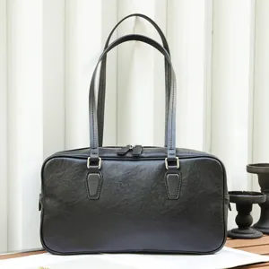 Detail view of black leather shoulder bag, minimalist retro design with double straps and zipper.