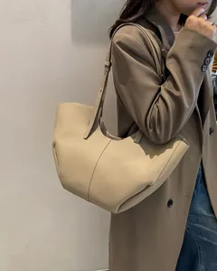 Vista dettagliata della borsa tote in pelle indossata dalla modella con design versatile.