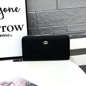 Close-up detail of black leather long wallet with zipper closure and metallic double ring logo.