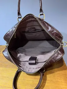 Detalle interior de maletin de cuero genuino retro, bolso grande para ordenador.