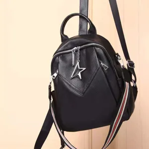 Schwarzer Damen-Rucksack aus echtem Leder mit Sternanhänger und gestreiften Schulterriemen.