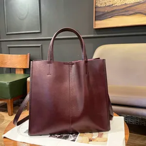 Detailed view of the dark red leather tote bag in a lifestyle indoor setting, elegant style.