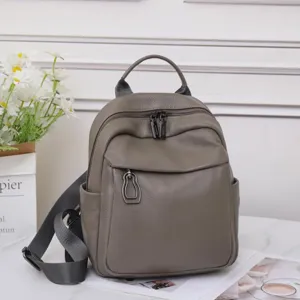 Detailed view of gray genuine leather backpack, soft texture, multi-functional daily commute.