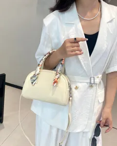Detalle del bolso de mano bowling de cuero genuino crema con elegante decoracion de panuelo