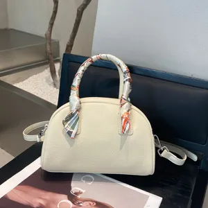 Elegante bolso de mano cúpula de cuero crema con detalle de pañuelo para el trabajo.