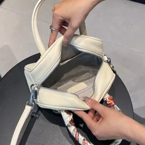 Detalle interior de bolso de mano de cuero con compartimento espacioso y forro suave.