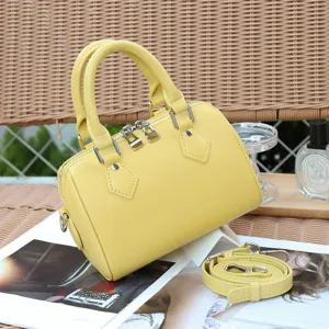 Detailed view of the yellow genuine leather Boston bag, featuring top handles and strap.