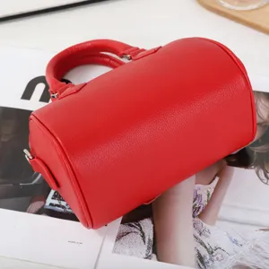 Red cowhide leather Boston bag detail showing premium texture and classic handbag design.