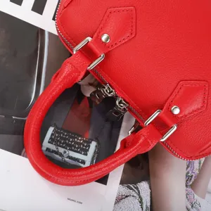 Red genuine leather Boston handbag, classic dome pillow bag design with durable metal zippers.
