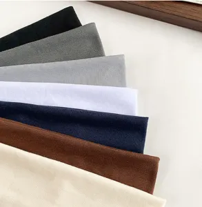 Close-up of wide elastic hair bands in assorted Morandi solid colors, soft textured fabric.
