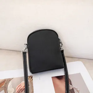 Black genuine leather vertical crossbody phone bag, compact mini shoulder purse for women.