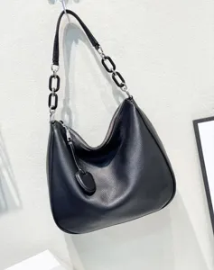 Detail view of black leather hobo shoulder bag featuring stylish chain strap and soft texture.