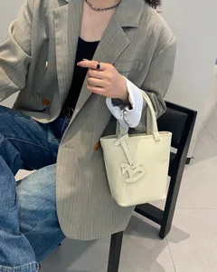 Echtleder Eimer Handtasche Detailaufnahme mit minimalistischem Design und niedlichem Pferdeanhänger.