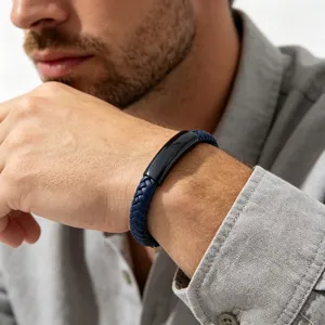 Close-up of men's royal blue braided leather bracelet with black curved plate and clasp detail.