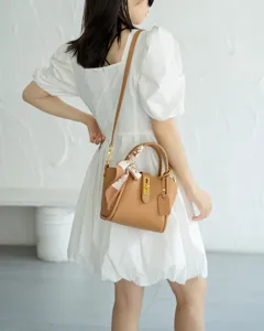 Genuine leather bucket handbag for women, brown cowhide crossbody bag with scarf and lock.