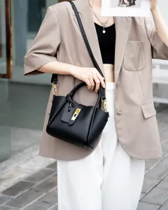 Detailed view of black genuine leather bucket bag with top handle and gold lock hardware.