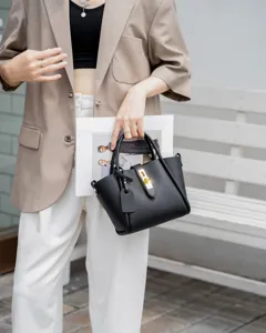 Black genuine leather bucket bag for women, versatile tote with chic metal lock closure.