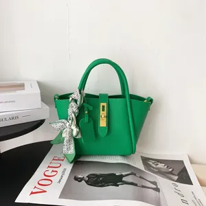 Green genuine leather bucket bag with metal lock and stylish twilly scarf detail.