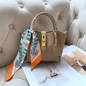 Detailed shot of a beige leather bucket bag with a chic hot air balloon patterned scarf.