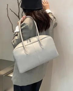 Detailed view of a minimalist light grey leather shoulder tote bag, ideal for daily commute.