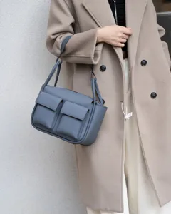 Stylish genuine leather shoulder bag with double front pockets in elegant blue grey.