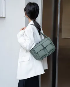 Detail view of genuine leather shoulder crossbody bag featuring multi pockets in green finish.