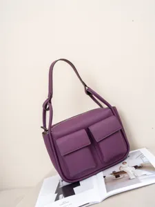 Elegant purple leather shoulder bag featuring dual front pockets and spacious interior.