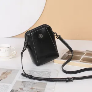 Sac bandoulière noir en cuir véritable pour femme avec coutures élégantes et détail en métal.
