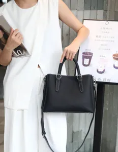 Vue de détail du sac cabas en cuir noir montrant de belles coutures blanches et poignées.