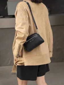 Black leather crossbody bag for women, stylish commuter shoulder bag with zipper and rivets.