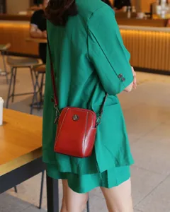 Petit sac bandoulière en cuir véritable pour femme, finition cirée, détail élégant rouge.